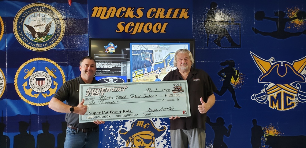 Mr. Alvin Heathman (at right) presents Dr. Josh Phillips with a $10,000 check for MC students on behalf of Super Cat Fest 4 Kids.